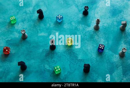 pezzi da scacchi e dadi colorati su uno sfondo blu acquerello Foto Stock