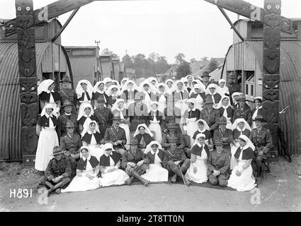 Gli infermieri e gli ufficiali medici del New Zealand Stationary Hospital, Wisques, Francia, Un ritratto di gruppo delle infermiere e degli ufficiali medici del New Zealand Stationary Hospital riuniti sotto un arco scavato da un paziente Maori. Seduto in seconda fila c'è la Matron Evelyn G. Brooke. Attraverso l'arco sono visibili file di capanne e tende. Foto scattata durante la prima guerra mondiale, il 16 agosto 1918 Foto Stock