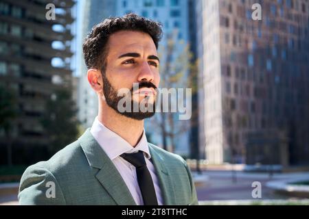 Uomo d'affari maturo e di successo, serio e sicuro di sé che si guarda intorno a un ufficio esterno in un centro finanziario Foto Stock