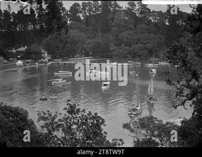 Barche a Mansion House Bay, Kawau Island - foto scattata da W T Matthews, Vista della Mansion House Bay che guarda in basso sulla baia da un punto panoramico a nord. Mansion House può essere vista sulla sinistra parzialmente oscurata dagli alberi e il molo è a media distanza. Una tenda è eretta vicino al litorale. Nella baia sono ormeggiate numerose barche e yacht. In primo piano, a sinistra, ci sono due barche a remi. preso nei primi anni '1900 Foto Stock