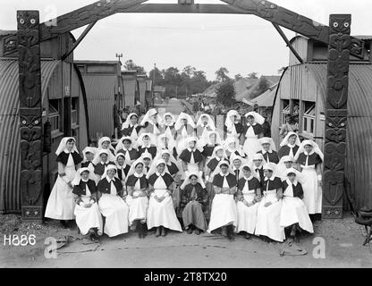 Le infermiere del New Zealand Stationary Hospital, Wisques, Francia, Un ritratto di gruppo delle infermiere neozelandesi del New Zealand Stationary Hospital riunite sotto un arco scolpito da un paziente Maori. Al centro c'è la Matron Evelyn Gertrude Brooke. Attraverso l'arco sono visibili file di capanne. Foto scattata durante la prima guerra mondiale, il 16 agosto 1918 Foto Stock