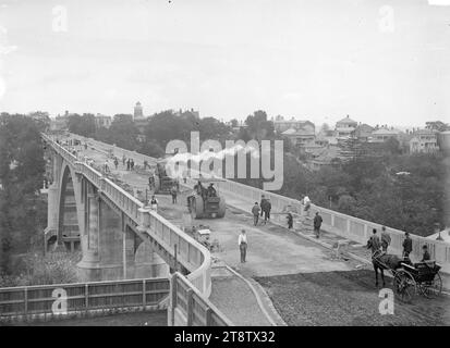 Grafton Bridge, Auckland, nuova Zelanda, in costruzione, Vista del Grafton Bridge, Auckland, nuova Zelanda, in costruzione, circa 1910 preso dalla Park Road End Le tombe possono essere viste nel Symonds Street Cemetery, sul lato sinistro, nella gola sotto il ponte. Le case possono essere viste sul lato destro (St Martin's Street e Symonds Street). Gli uomini stanno lavorando sulla strada, alcuni su rulli a vapore e i pedoni stanno attraversando il ponte mentre è ancora in costruzione. Un cavallo e una carrozza sono in primo piano Foto Stock