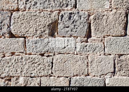 Parete vecchia fatta di blocchi di pietra beige, vista ravvicinata esterna della superficie di pietra rettangolare, muratura Foto Stock