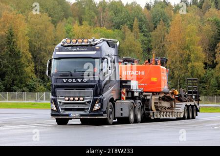 Volvo FH16 Truck Mynttinen con rimorchio con pala ribassata che trasporta l'escavatore Hitachi Zaxis 225 come carico largo in un giorno d'autunno. Forssa, Finlandia. 21 settembre 2023. Foto Stock