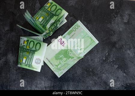 100 banconote in euro sparsi sul tavolo pagando le tasse inflazione in Europa Foto Stock