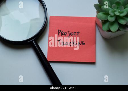 Concetto di tracciamento del progetto scrivere su appunti isolati su un tavolo di legno. Foto Stock