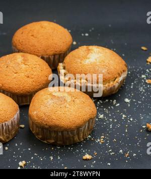 Muffin dolci, cupscake food, torta di muffin per la colazione mattutina su sfondo nero. Foto Stock
