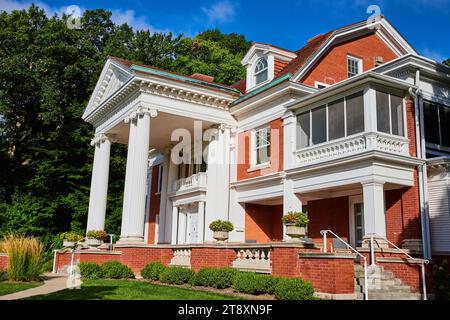 Edificio della tenuta presso il Minnetrista Museum and Gardens in una giornata di sole con cielo blu e foresta Foto Stock