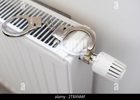 Manette sul radiatore. Manette e colletto della polizia. Foto Stock