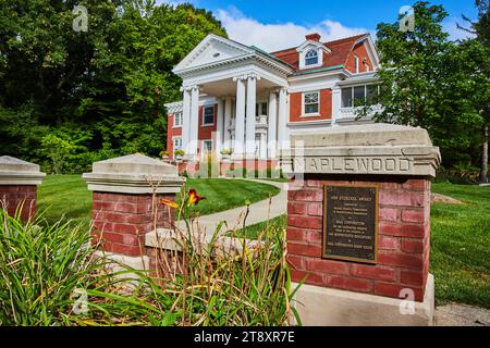 Cartello per l'edificio Maplewood all'entrata del Museo Minnetrista e dei giardini con fiori e cielo blu Foto Stock