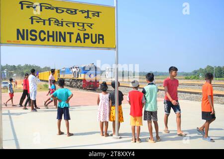 Gli indiani guardano un treno di prova e scattano fotografie, che sta attraversando il confine Indo-Bangladesh. Il treno partì dalla stazione di Gangasagar in Bangladesh e raggiunse la stazione di Nischintapur per la prima volta alla periferia di Agartala. Tripura, India. Foto Stock