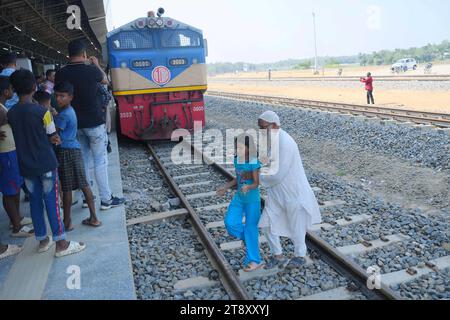 Gli indiani guardano un treno di prova e scattano fotografie, che sta attraversando il confine Indo-Bangladesh. Il treno partì dalla stazione di Gangasagar in Bangladesh e raggiunse la stazione di Nischintapur per la prima volta alla periferia di Agartala. Tripura, India. Foto Stock