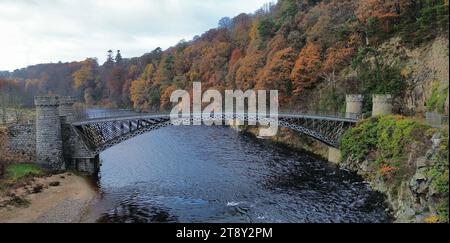 Un pittoresco ponte di Craigellachie si erge sullo sfondo di un fogliame autunnale, arroccato su un torrente di montagna, in Scozia Foto Stock