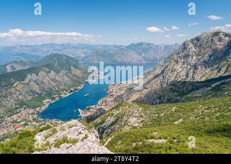 Una vista panoramica della Baia di Cattaro in Montenegro, circondata da ripide montagne rocciose. L'acqua blu della baia curva attraverso il paesaggio. Foto Stock