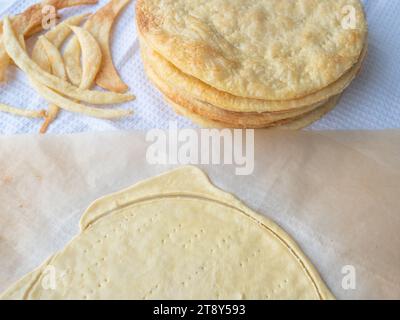 Cucinare una pasta sfoglia di pasta sfoglia alla francese con una pila di sottili strati di burro dorati al forno, frammenti di impasto e strato crudo arrotolato su carta da forno Foto Stock