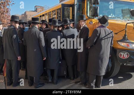 Un grande gruppo di ebrei satmar ultra ortodossi di Williamsburg sale a bordo di un autobus per andare a un seminario sul Talmud in un altro quartiere. 19 novembre 2023. Foto Stock