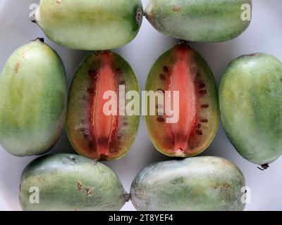 Berlino, Germania. 7 novembre 2023. Una bacca di kiwi verde tagliata a metà si trova tra i frutti interi su un piatto. Credito: Soeren Stache/dpa/Alamy Live News Foto Stock