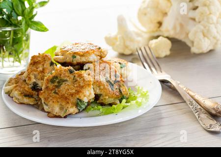 cotolette di cavolfiore fritte vegetariane, in un piatto su un tavolo di legno. Foto Stock