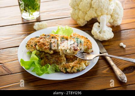 cotolette di cavolfiore fritte vegetariane, in un piatto su un tavolo di legno. Foto Stock