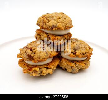 Foto ravvicinata dei biscotti con torta di panna di farinata d'avena con noci e gocce di cioccolato e ripieno di crema di burro Foto Stock