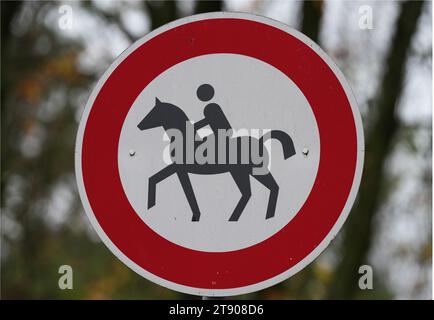 Stahnsdorf, Germania. 21 novembre 2023. La raffigurazione di un cavaliere e di un cavallo su un cartello bianco con un bordo rosso all'inizio di un sentiero nella foresta significa "cavalcare vietato". Credito: Soeren Stache/dpa/Alamy Live News Foto Stock