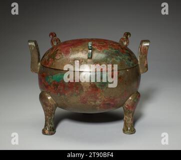 Recipiente alimentare Ding, III secolo a.C., 6 3/4 x 8 3/4 x 7 7/16 pollici, 3,7 libbre (17,1 x 22,2 x 18,9 cm, 1,7 kg), Bronzo, Cina, III secolo a.C., il calderone alimentare, noto come ding, era il tipo di vaso rituale più importante durante l'età del bronzo cinese. Era usato per cucinare, tenere e condire la carne durante le cerimonie dedicate agli spiriti ancestrali. Le maniglie verticali hanno consentito di abbassare e rimuovere l'imbarcazione da un incendio aperto. Come parte delle pratiche funerarie, tale ding di bronzo fu sepolto con il defunto. Il numero di componenti costituenti un insieme dipendeva dallo stato dell'occupante della tomba. Foto Stock