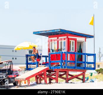 Cocoa Beach, Florida, USA - 27 giugno 2023: Stazione di bagnino sulla spiaggia con un uomo seduto. Foto Stock