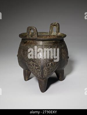 Tripode li, vaso alimentare, XIII secolo a.C., 6 7/16 x 5 9/16 x 5 3/8 pollici, 2 libbre (16,3 x 14,1 x 13,7 cm, 0,9 kg), Bronzo, Cina, XIII secolo a.C., questo vaso a tre lobi è realizzato in rilievo piatto con tre maschere taotie che comprendono la decorazione principale. Mentre i motivi sul fregio superiore, dove lo spazio è più limitato, sono semplici TS stilizzati, le maschere sulle gambe sono straordinariamente complesse. Gli occhi sporgenti sono circondati da corna arrotolate; il suo corpo e la coda arricciata sono mostrati in profilo circondati da spirali. Il treppiede è un buon esempio di vaso rituale in bronzo Shang Foto Stock