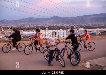 Antakya, Hatay, Turchia. 3 novembre 2023. I bambini vanno in bicicletta donati da organizzazioni di beneficenza internazionali vicino alla città container nel quartiere di Kuzeytepe che attualmente chiamano casa. Circa 150 mila persone che hanno perso le loro case ora vivono in decine di città container istituite intorno al distretto di Antakya, che è stato dedicato dopo i terremoti. Fondata dall'AFAD, la Presidenza di gestione delle emergenze e dei disastri è una delle più grandi di Hatay, con una popolazione di oltre 10 mila abitanti. (Immagine di credito: ¬ © tolga Ildun/ZUMA Press Wire) SOLO USO EDITORIALE! Non per Comme Foto Stock