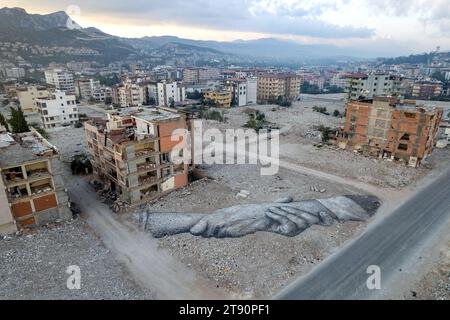 Kahramanmaras, Hatay, Turchia. 3 novembre 2023. L'artista francese Guillaume Legros, noto come Saype, creò un'opera d'arte raffigurante mani intrecciate che stringono la mano per attirare l'attenzione sulla distruzione di Hatay. L'opera d'arte si trova ad Armutlu, un quartiere di Antakya che è stato quasi completamente distrutto. (Immagine di credito: © tolga Ildun/ZUMA Press Wire) SOLO USO EDITORIALE! Non per USO commerciale! Foto Stock