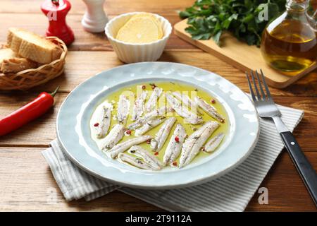 Gustosi acciughe sott'aceto con spezie su un tavolo di legno Foto Stock