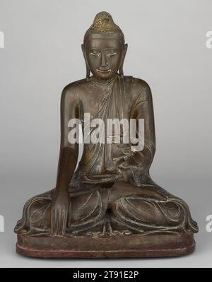 Shakyamuni Buddha Calling the Earth to Witness, XVIII secolo, 28 x 21 x 14 1/2 poll. (71,12 x 53,34 x 36,83 cm), Bronzo, Myanmar (Birmania), Dinastia Konbaung (1752-1885), tenendo la mano sinistra palmo in grembo ed estendendo la mano destra per toccare il terreno davanti a lui, questa immagine birmana dello storico buddha, Shakyamuni, fa un gesto noto come bhumisparsha-mudra, o "chiamare la terra a testimoniare". È una rappresentazione del momento immediatamente dopo la sua illuminazione. Mentre meditava, il Buddha fu bombardato da un esercito di demoni inviati da Mara, ma fu in grado di superare queste distrazioni Foto Stock