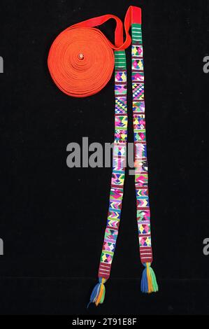 Copricapo (xk'ap), c. 1970, 521 x 11/16" (1323,3 x 4,3 cm) (con nappine), cotone, sintetico, filo metallico, Guatemala, nel XX secolo, per generazioni, le donne di Santiago Atitlán hanno ferito lunghe, strette bande rosse intorno alla testa per creare un caratteristico effetto alone. La banda che forma l'xk'ap può misurare oltre 40 piedi di lunghezza e si dice che rappresenti il Serpente Arcobaleno. Il Serpente Arcobaleno è equiparato a uno spettacolare fenomeno naturale, l'etereo alone cosmico che a volte circonda la luna nelle notti piovose Foto Stock