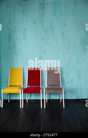 Tre sedie colorate all'interno della sala blu Foto Stock