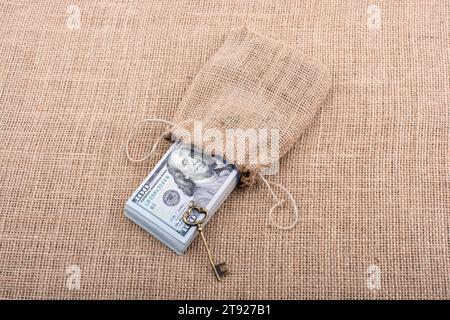 Chiave retrò e il pacchetto del dollaro USA in un sacco su una tela di canapa Foto Stock