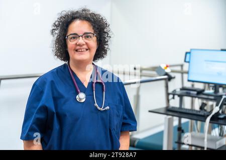 Ritratto di un cardiologo maturo sorridente orgoglioso di braccia incrociate in ospedale Foto Stock