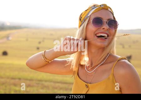 Bella donna hippie felice con spikelet in campo Foto Stock