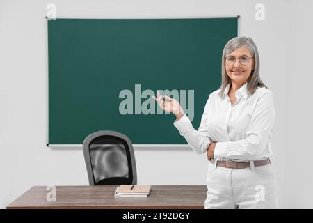 Ritratto del professore vicino alla lavagna in classe, spazio per il testo Foto Stock