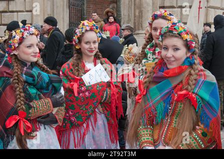 Giovani donne che indossano costumi e ghirlande della regione di Cracovia, si preparano per la Cavalcata di Magi, la processione delle festività dell'Epifania, Cracovia, Polonia Foto Stock