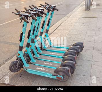 Sofia, Bulgaria - 16 ottobre 2023: Scooter elettrici Binbin a noleggio ordinatamente parcheggiati presso il marciapiede nel centro città il giorno d'autunno. Foto Stock