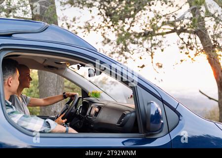 una bella coppia che guida un camper durante il viaggio in auto Foto Stock