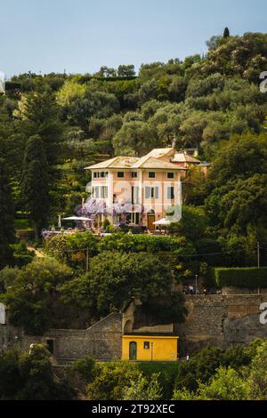 Una struttura pittoresca sul fianco della collina circondata da una lussureggiante vegetazione. Portofino, Italia Foto Stock