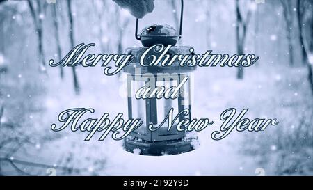 Buon Natale e felice anno nuovo, parole, design celebrazione. Uomo che tiene in mano una torcia a candelabro sullo sfondo di alberi innevati nella foresta in inverno durante le nevicate. Sfondo del testo Foto Stock