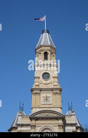 Dettaglio della torre dell'orologio e campanile di Fremantle Town Hall 1887, Fremantle, Australia Occidentale con la bandiera australiana che sventola nel vento Foto Stock