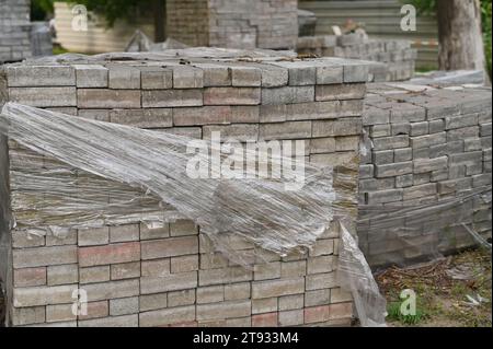 I mattoni grigi sono impilati in cubi. Blocchi bianchi di mattoni in magazzino su mattoni di magazzino. Foto Stock