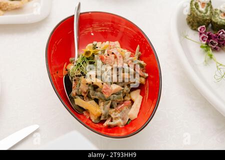 Insalata di fegato con asparagi, pomodori e microgreen serviti in un recipiente rosso. Foto Stock