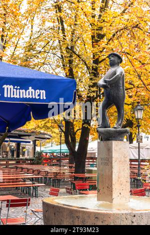 La statua di Weiss Ferdl si trova da sola in The Rain, Viktualienmarkt, Monaco di Baviera, Germania Foto Stock