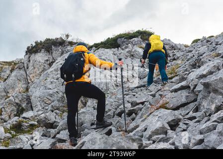 un paio di alpinisti che fanno una salita alla montagna tra le rocce. due persone che fanno escursioni in alta montagna. sport all'aperto Foto Stock