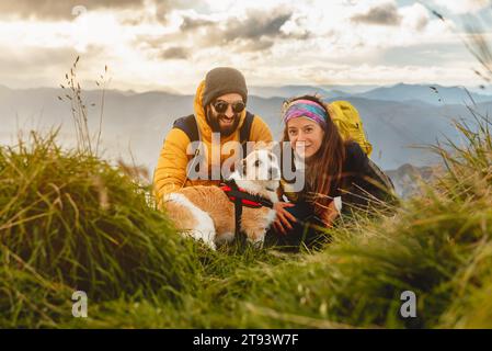 ritratto di due escursionisti con il loro cane in montagna. viaggia con una coppia di cani per fare trekking in montagna. Foto Stock