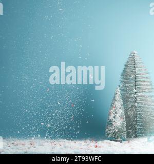 Sfondo invernale, natalizio o Capodanno con abeti e neve che cade in blu Foto Stock